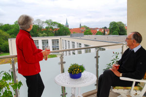 Foto von einem Paar auf dem Balkon einer unserer Wohnungen.